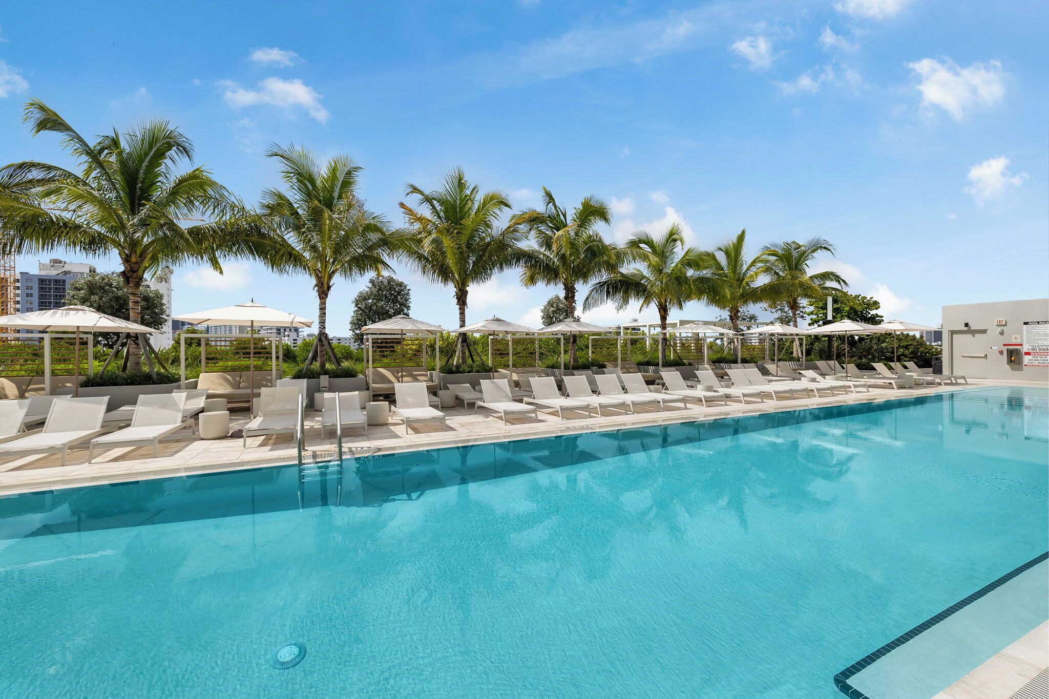 Una piscina al aire libre, camas de piscina gratis, sombrillas