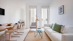 A modern living room with a dining area, a sofa, and a TV mounted on the wall. - The Superior Green at BoaVista Flats (Porto)