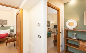 Habitación de hotel con cama, una silla, un escritorio y una televisión al fondo.