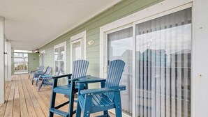 A covered porch with blue Adirondack chairs and a wooden deck. - Spacious 3BR 2BA Gulf Views Dock and Boat Launch (Gulf Shores)