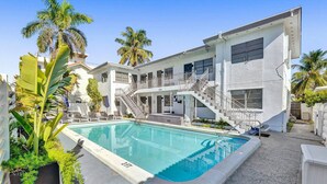A modern hotel with a swimming pool, outdoor seating, and palm trees. - Waves on Desoto Studio With Pool 3 (Hollywood)