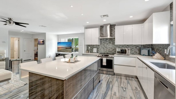 A modern kitchen with white cabinets, a marble island, and a built-in oven. - Daddy House-victoria Park With Pool (Fort Lauderdale)