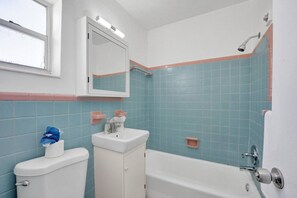 A bathroom with a toilet, sink, and bathtub. - Waves on Desoto Beautiful Studio 7 (Hollywood)