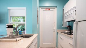 A modern kitchen with a sink, a dish rack, a microwave, and a refrigerator. - Casa Del Mar Deluxe Studio 2 (Hollywood)