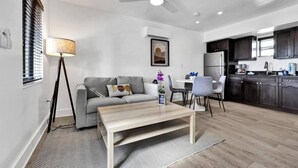 Una sala moderna con sofá, mesa de centro y comedor.
