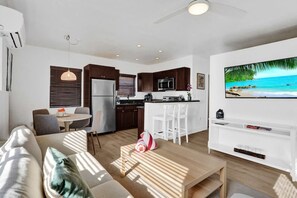 A modern living room with a sofa, a coffee table, and a TV. - New Waves on Walnut 1 (Hollywood)