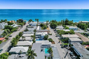 Vista aérea de una zona costera con edificios, piscina y una vista despejada del océano.