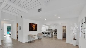 Amplia sala de estar con cocina, comedor y un gran ventanal.