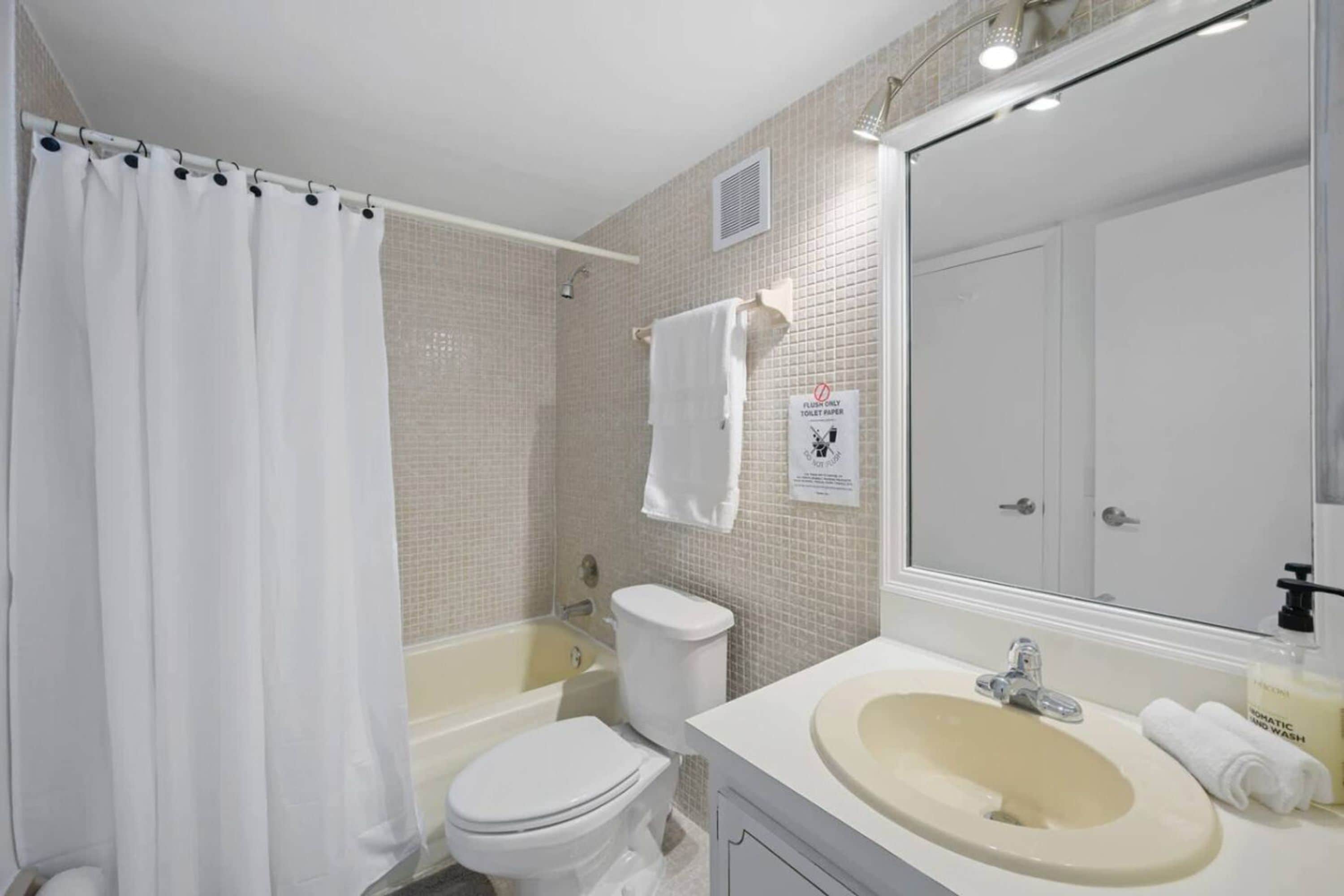 A bathroom with a bathtub, toilet, and sink.