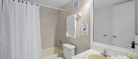 A bathroom with a bathtub, toilet, and sink.