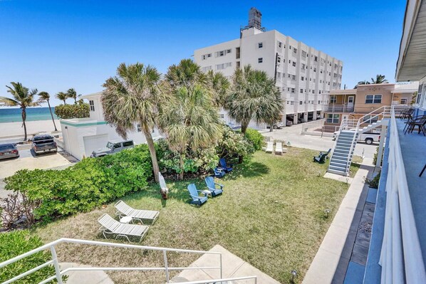 A hotel courtyard with a pool, palm trees, and lounge chairs. - Marine Villas 8 in Hollywood (Hollywood)