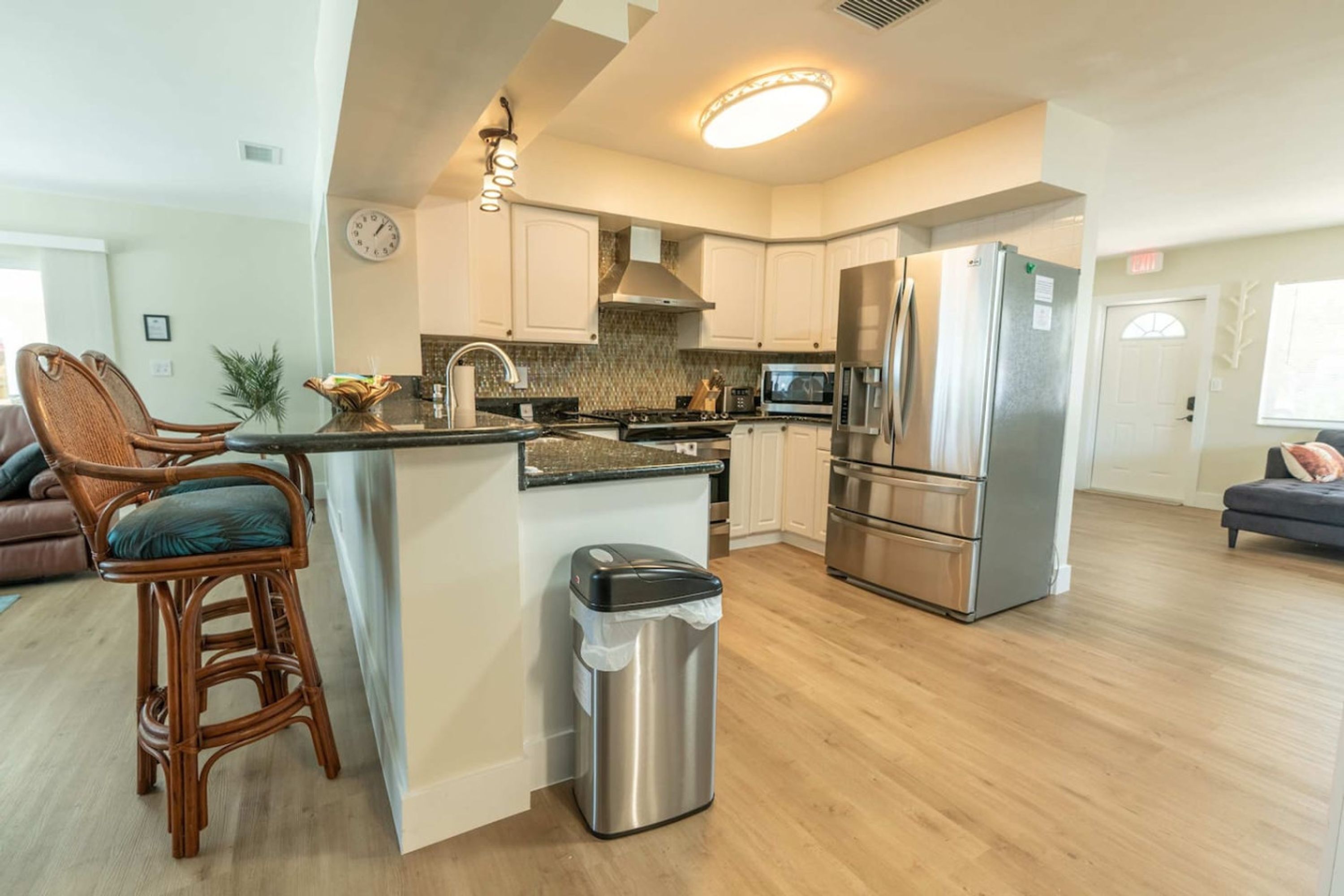 A modern kitchen with white cabinets, stainless steel appliances, and a central island.