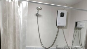 Un bagno con doccia, lavandino, WC e cestino.