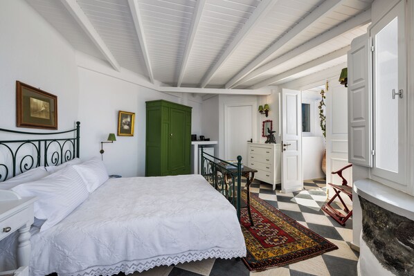 Une chambre à coucher avec un lit, une commode et une armoire verte.