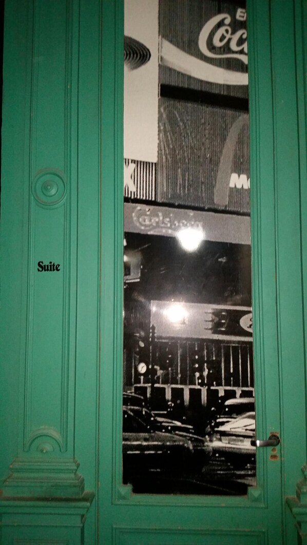 A green door with a window reflecting a nighttime cityscape. - Che Pampa´s Hostel (Rosario)
