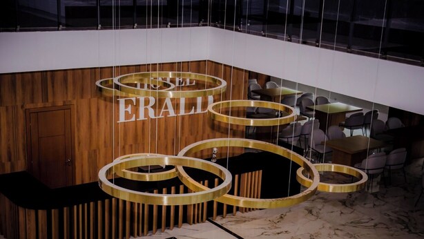 En moderne lobby med en træreception og en rund lysekrone.