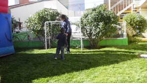 A grassy outdoor area with a goalpost, a small tree, and a building in the background. - Hostel Viajeros (Puerto Madryn)