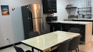 A modern kitchen with a stainless steel refrigerator, a microwave, and a built-in oven. There is a dining table with chairs and a rug on the floor. - Welcome to Ocean's Tropical Escape!
Beach front, beach access 1-bedroom, 4 bed. (Runaway Bay)