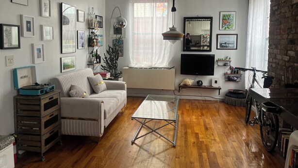 Un salon avec un canapé, une table basse, un téléviseur et une bibliothèque.