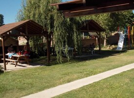A covered outdoor area with picnic tables and a playground.