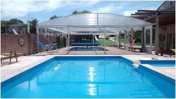 A rectangular swimming pool with a transparent canopy overhead.