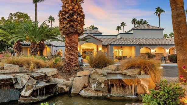 A hotel with a pool, palm trees, and a waterfall. - Landing | Modern 2BD, Gym, Pool (Phoenix)