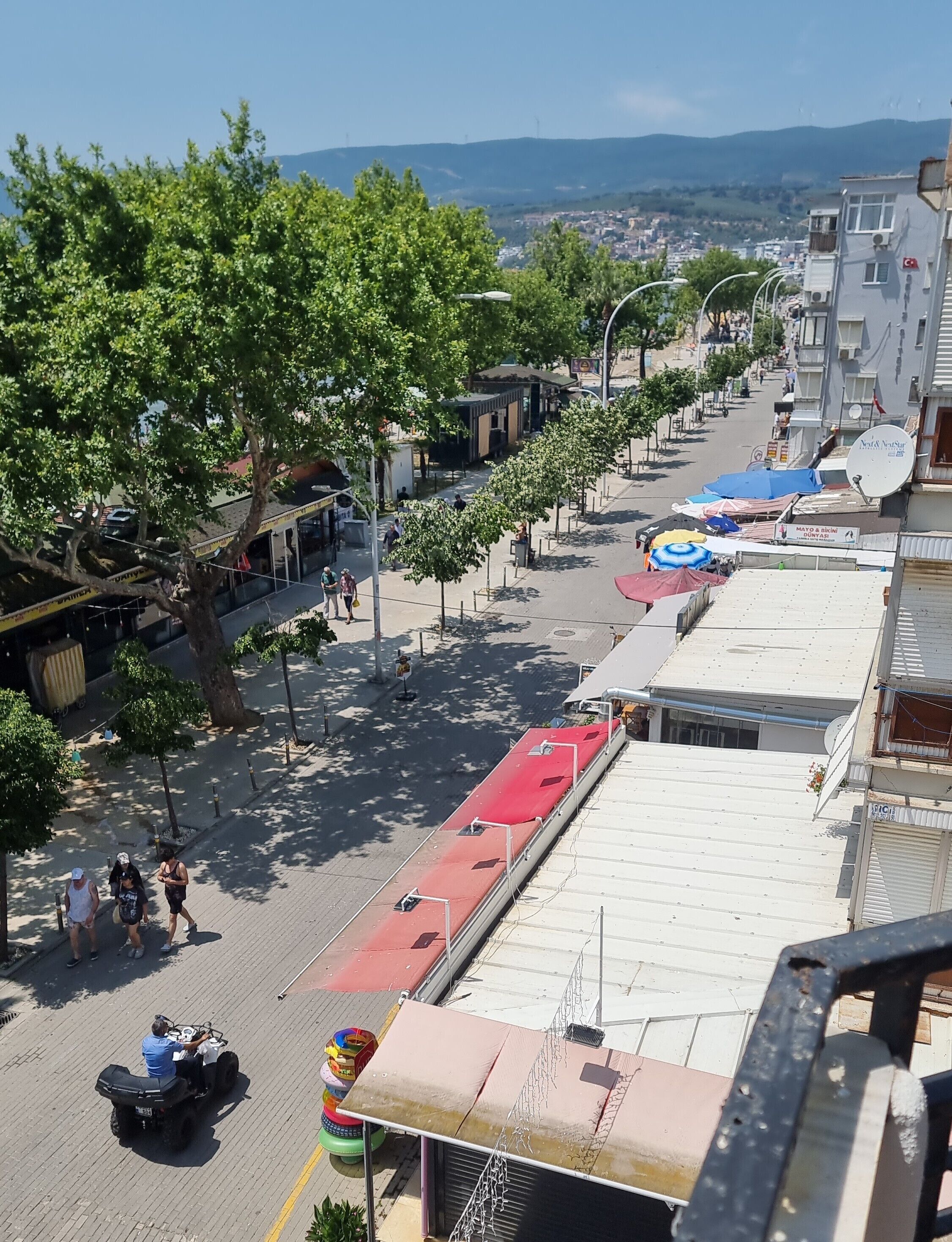 A street view with buildings, trees, and a clear sky.