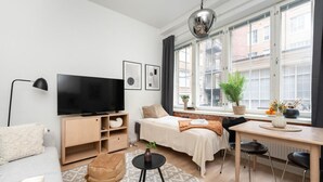 A modern, well-lit room with a bed, desk, and TV. - Come in! `Värjäri` Stunning stud (Tampere)