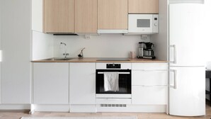 A modern kitchen with white cabinetry, a microwave, a coffee maker, and an oven. - Come in! `Vapari 2` Astonishing studio in stadium! (Tampere)