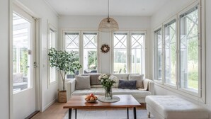 Una habitación luminosa con un sofá, una mesa de centro y una lámpara colgante.