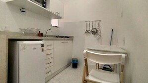 A compact kitchen with a built-in refrigerator, a sink, and a small countertop. - Few steps from Ipanema & Arpoador Beaches (Ipanema)