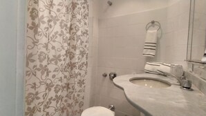 A bathroom with a toilet, sink, and shower curtain. - Few steps from Ipanema & Arpoador Beaches (Ipanema)