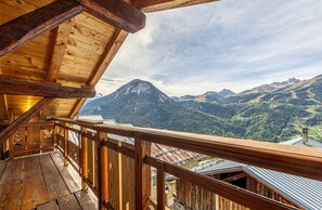 Un balcón de madera con vista a la montaña.