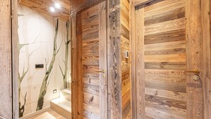 A wooden interior with a staircase and a wall with a tree design.