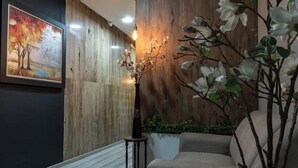 Une pièce avec un mur en bois, un tableau encadré, un vase de fleurs et un canapé.