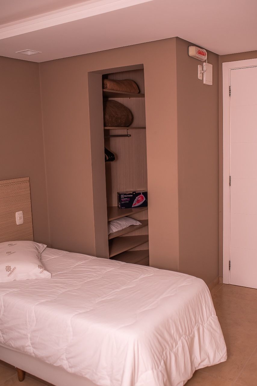 A bedroom with a bed, a closet, and a door.