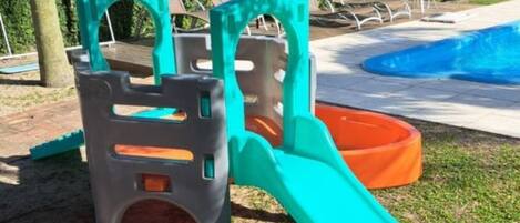A playground with a slide and climbing structures.