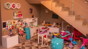 Un cuarto de juegos infantil con juguetes, un escritorio y una escalera.