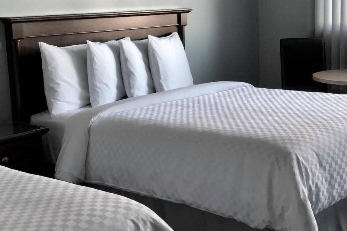 Une chambre d’hôtel avec un grand lit, une table de chevet, une table ronde et une chaise.