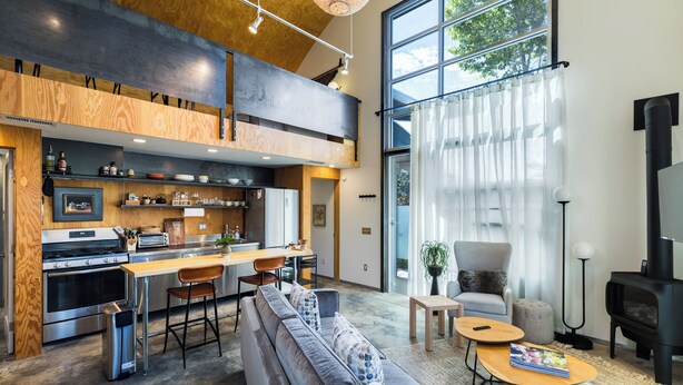 Una cocina moderna con comedor, sofá y chimenea.