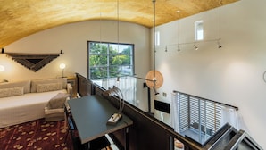 Un interior moderno con techo de madera, un sofá, una mesa de comedor y una escalera.