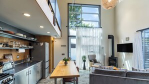 Una cocina moderna con comedor, sofá y televisor.