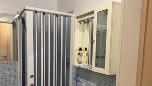 A bathroom with a shower, a sink, and a mirror.