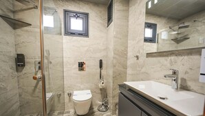 A modern bathroom with a glass-enclosed shower, a toilet, a sink, and a mirror. - Oliva Verde Hotel (Marmaris)