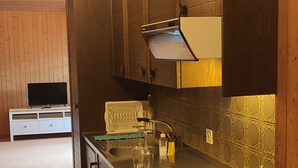 Una cocina compacta con estufa integrada, un lavamanos y armarios de madera.