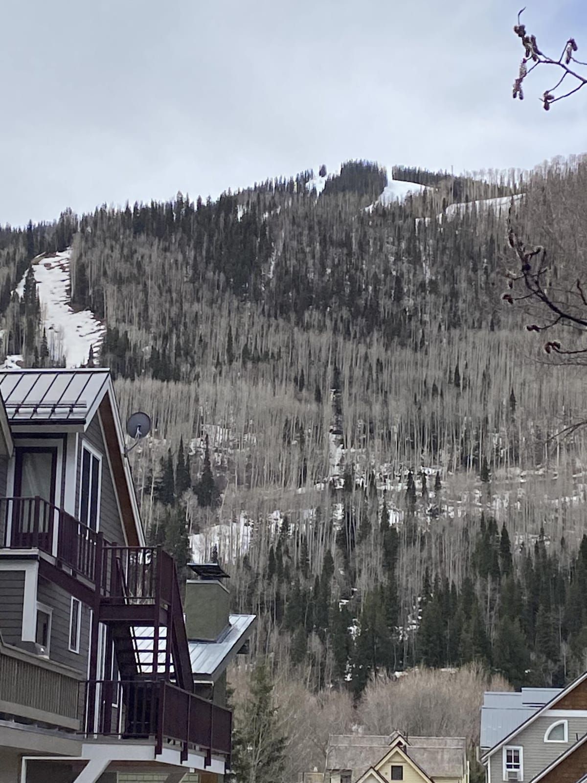 Un quartier résidentiel avec une maison dotée d’un balcon et offrant une vue sur les montagnes.