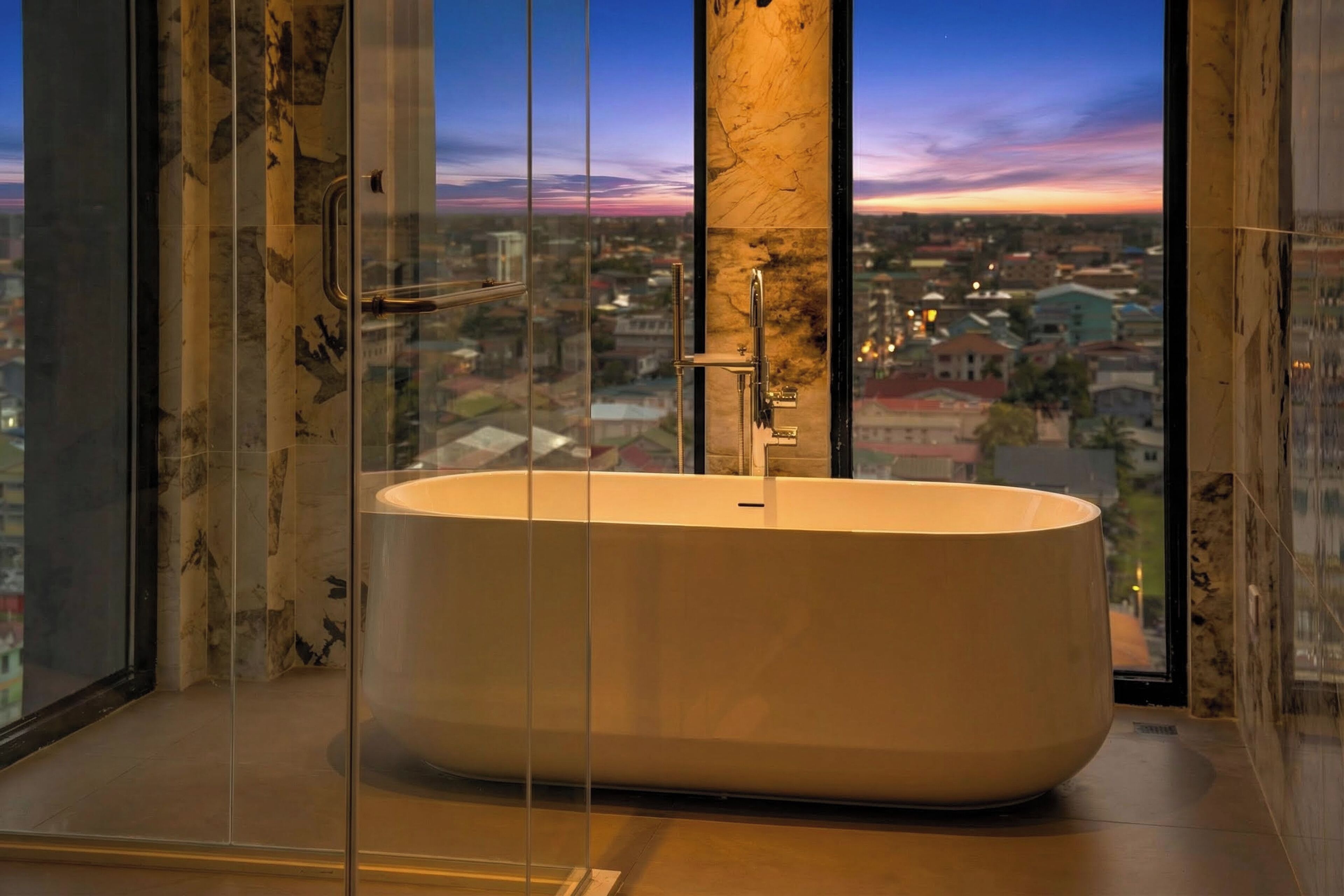 A modern bathroom with a freestanding bathtub, large windows, and a city view.