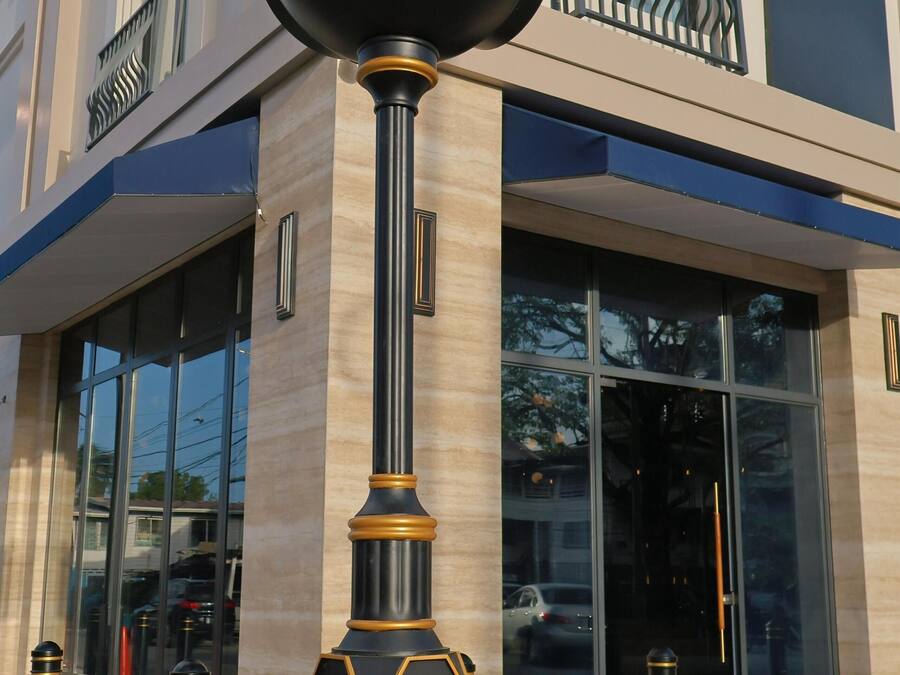 Un reloj con la inscripción 'Waterloo St' sujeto a un poste con detalles decorativos.