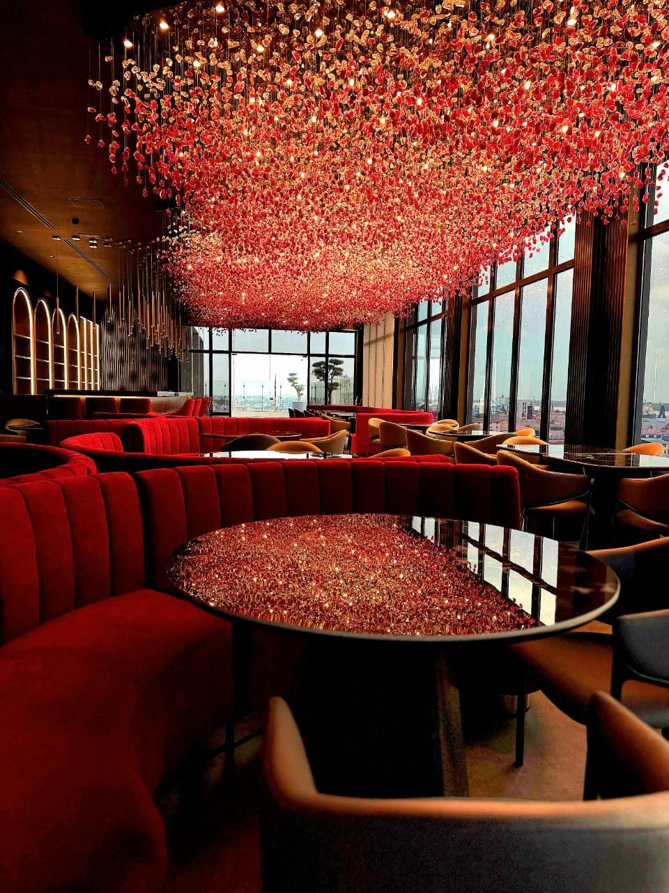 Un intérieur moderne avec des sièges rouges, une table centrale et un décor de plafond original.
