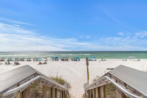A beach with a wooden deck leading to the sand, umbrellas, and lounge chairs. - 🎣 Crustacean Sensation | Community Pool | Boat Dock | Kayaks + Bikes + More!! (Navarre)